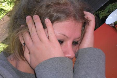 Eine Frau stützt ihr Gesicht in ihre Hände